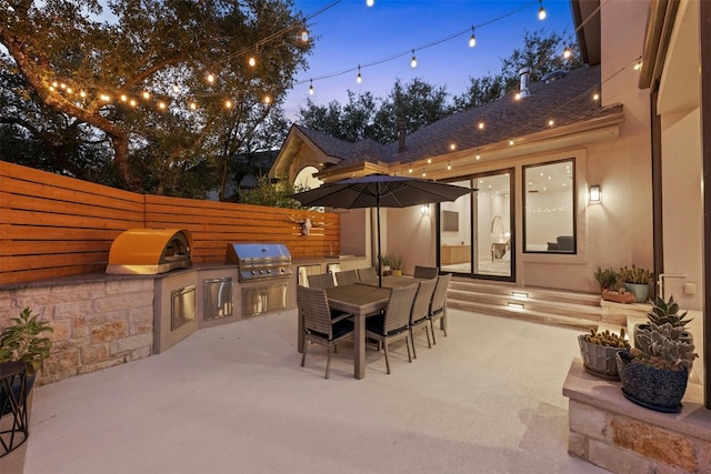 patio terrace at dusk with a grill and area for grilling