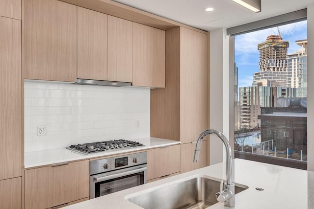 kitchen featuring light brown cabinetry, sink, and appliances with stainless steel finishes