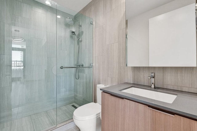 bathroom with tasteful backsplash, vanity, walk in shower, and toilet