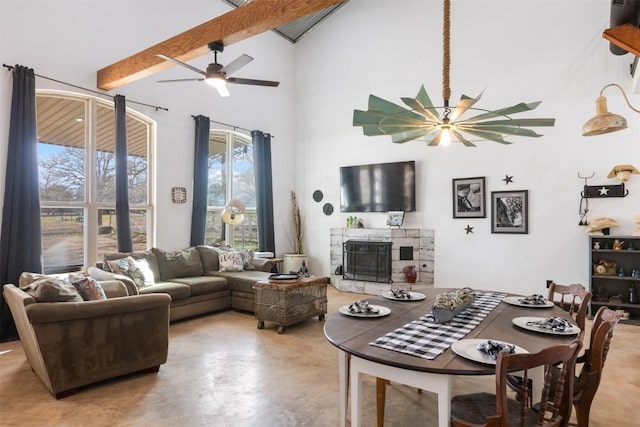 living room with beam ceiling, a healthy amount of sunlight, concrete floors, and a fireplace