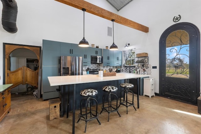 kitchen with blue cabinetry, a breakfast bar area, beamed ceiling, appliances with stainless steel finishes, and pendant lighting