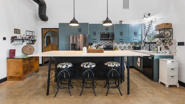 kitchen with stainless steel appliances, blue cabinets, a kitchen breakfast bar, and decorative light fixtures