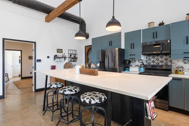 kitchen with a kitchen island, a breakfast bar area, hanging light fixtures, stainless steel appliances, and blue cabinetry