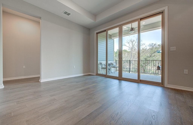 unfurnished room with visible vents, baseboards, and wood finished floors