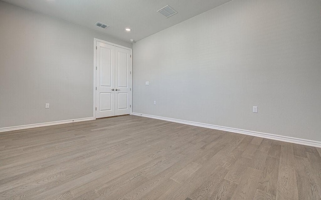 empty room with baseboards, visible vents, and light wood-style floors