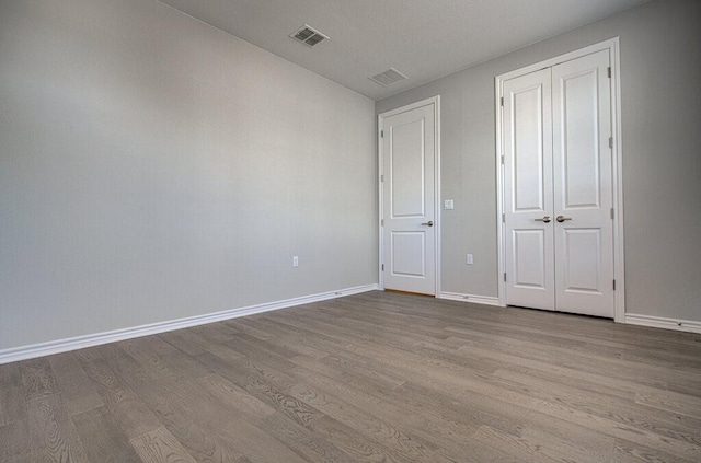128 Roaming Rock Trl Unit 102, San Marcos, TX 78666 - unfurnished bedroom with wood finished floors and a closet