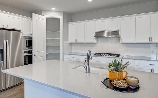 kitchen featuring stainless steel appliances, recessed lighting, decorative backsplash, white cabinets, and under cabinet range hood