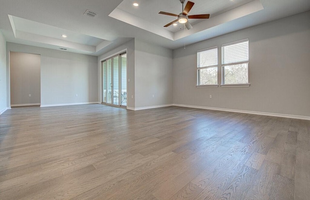 128 Roaming Rock Trl Unit 102, San Marcos, TX 78666 - empty room with a tray ceiling, ceiling fan, wood finished floors, and recessed lighting