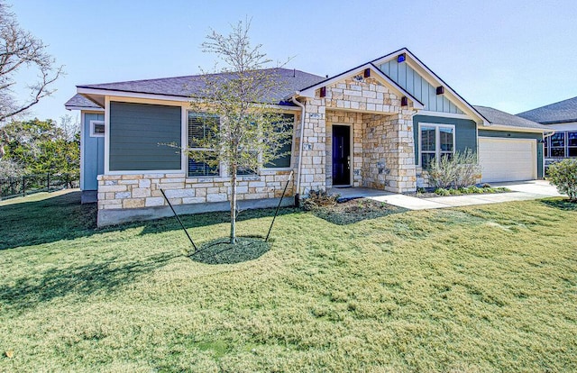 view of front of house featuring board and batten siding, an attached garage, a front lawn, and stone siding