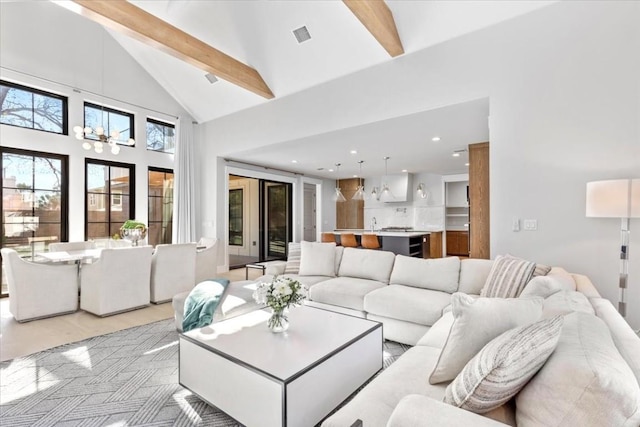 living room featuring beamed ceiling, an inviting chandelier, and high vaulted ceiling