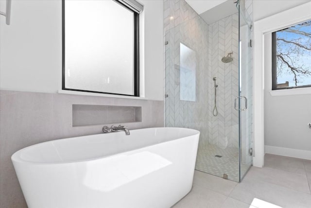 bathroom with tile walls, tile patterned floors, and separate shower and tub