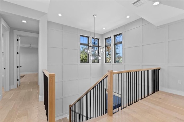 corridor featuring light hardwood / wood-style floors and a chandelier