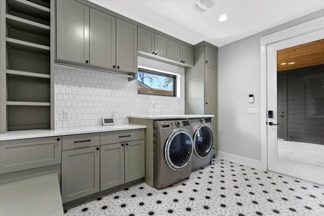 washroom featuring cabinets and washing machine and clothes dryer