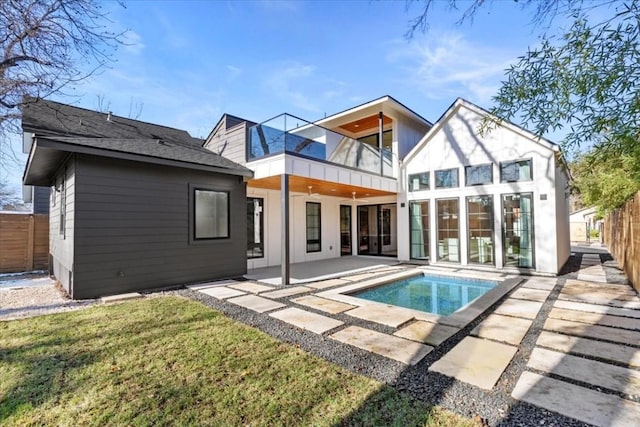 back of house featuring a fenced in pool, a balcony, a yard, and a patio area