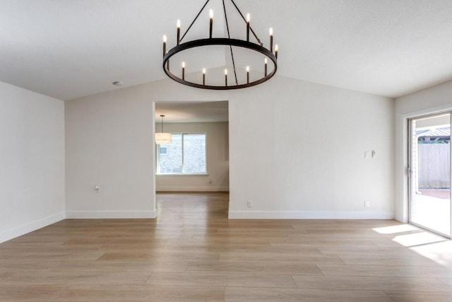 spare room with vaulted ceiling, light hardwood / wood-style flooring, and a wealth of natural light