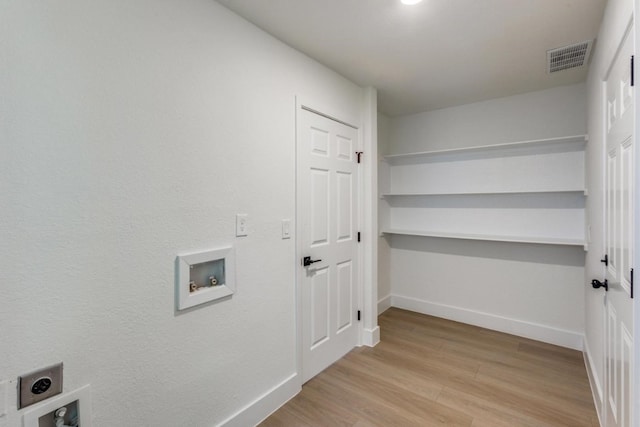 washroom featuring hookup for a washing machine, light hardwood / wood-style floors, and electric dryer hookup