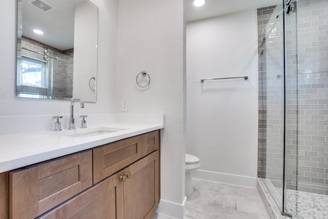 bathroom with vanity, toilet, and a shower with door