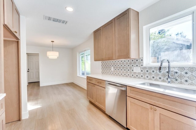 kitchen with pendant lighting, sink, decorative backsplash, stainless steel dishwasher, and light wood-type flooring