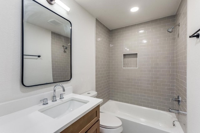 full bathroom featuring vanity, toilet, and tiled shower / bath combo