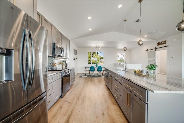 429 Summit Ridge Dr N, Point Venture, TX 78645 - kitchen featuring stainless steel appliances, a barn door, gray cabinetry, a sink, and vaulted ceiling