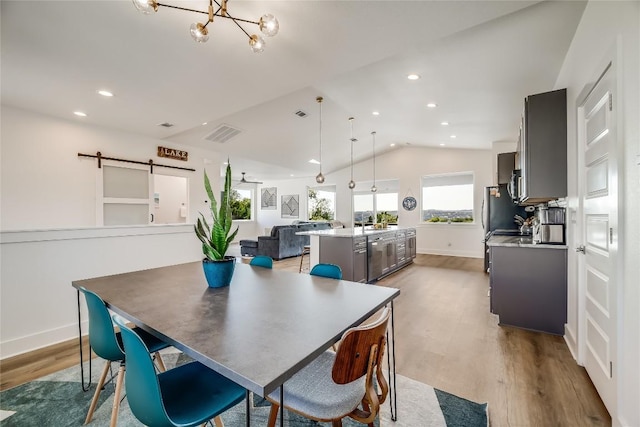 429 Summit Ridge Dr N, Point Venture, TX 78645 - dining space featuring a barn door, wood finished floors, lofted ceiling, baseboards, and a chandelier