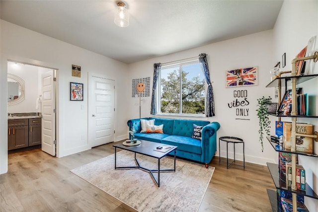 living area featuring light wood finished floors and baseboards