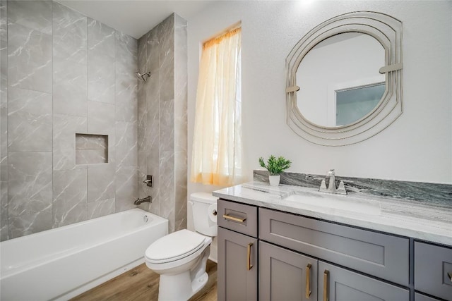 bathroom with wood finished floors, toilet, vanity, and bathing tub / shower combination
