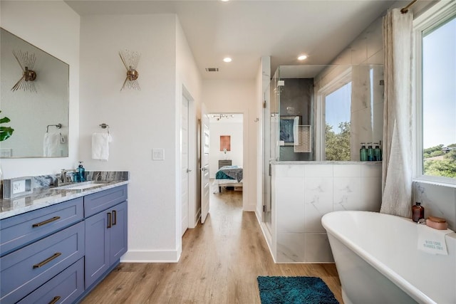 bathroom with hardwood / wood-style flooring, vanity, and independent shower and bath