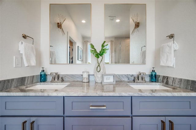 full bath with double vanity, a shower with door, and recessed lighting