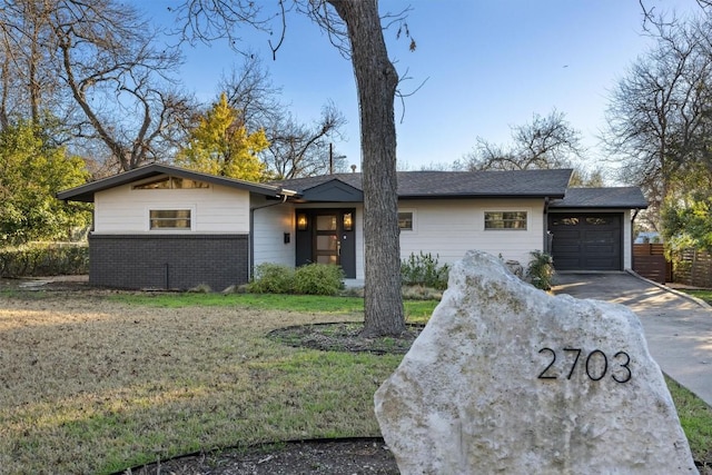 single story home featuring a garage and a front lawn