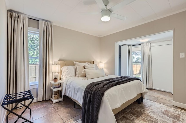 bedroom featuring ceiling fan, tile patterned flooring, multiple windows, and access to outside