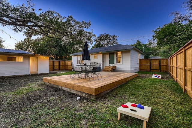 back of house featuring a wooden deck and a lawn