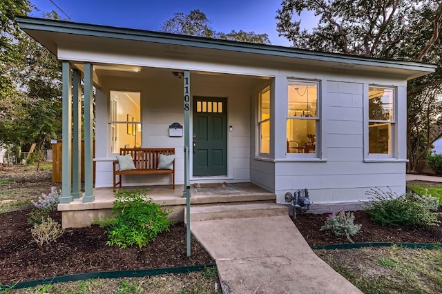 view of exterior entry with a porch