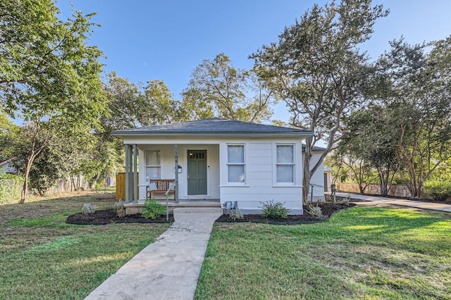 bungalow-style home featuring a front yard and covered porch