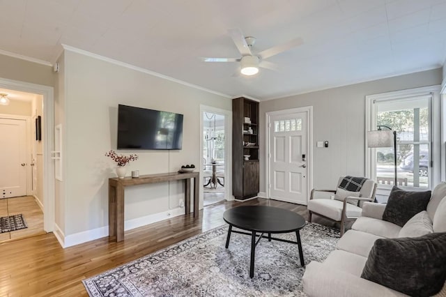 living room featuring ornamental molding, ceiling fan, and light hardwood / wood-style flooring