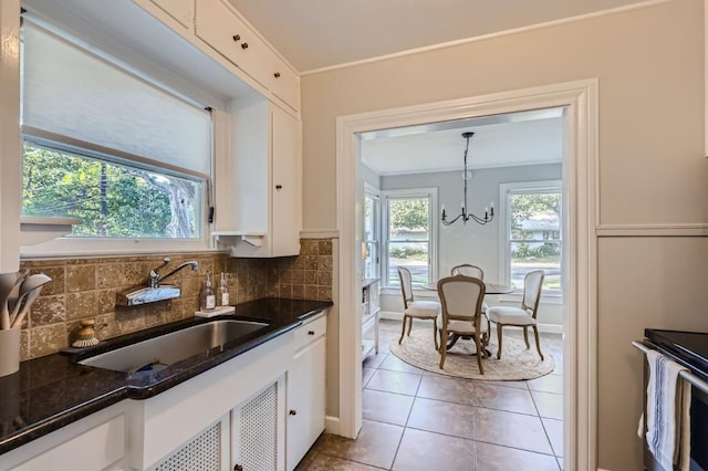 kitchen with sink, pendant lighting, white cabinets, and backsplash