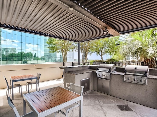 view of patio / terrace with a grill, fence, and an outdoor kitchen