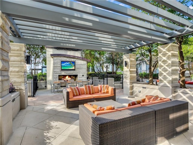 view of patio / terrace with an outdoor living space with a fireplace, fence, and a pergola