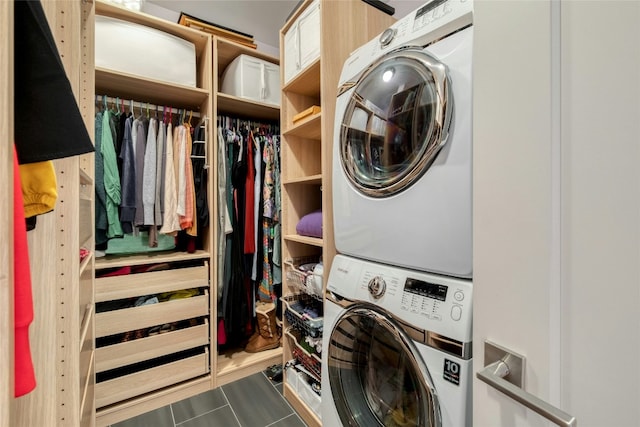 laundry room featuring laundry area, tile patterned floors, and stacked washer and clothes dryer