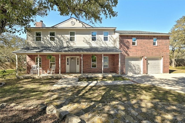 view of front of house with a garage, a front yard, and covered porch