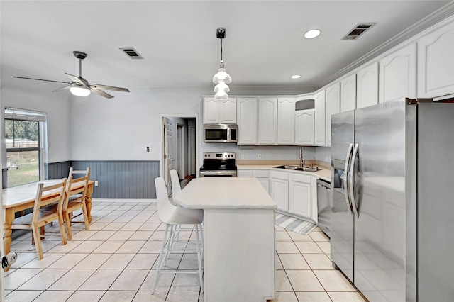 kitchen with stainless steel appliances, a center island, pendant lighting, and white cabinets