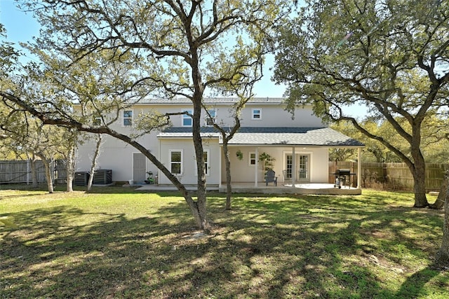 rear view of house with french doors, a patio, central AC unit, and a lawn