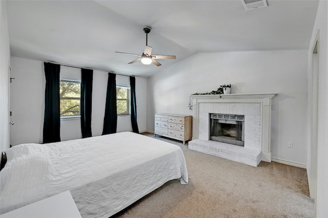 carpeted bedroom featuring lofted ceiling, ceiling fan, and a brick fireplace