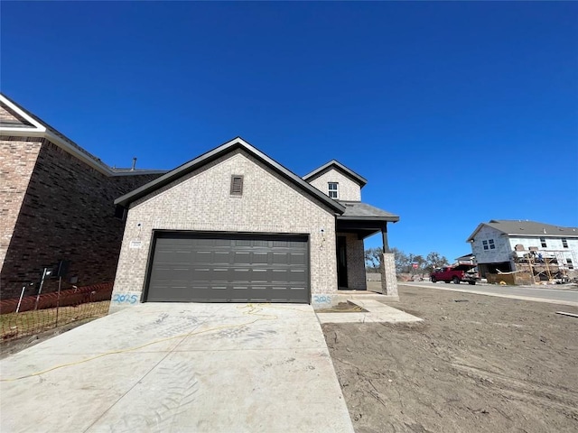 view of front facade featuring a garage, brick siding, and driveway