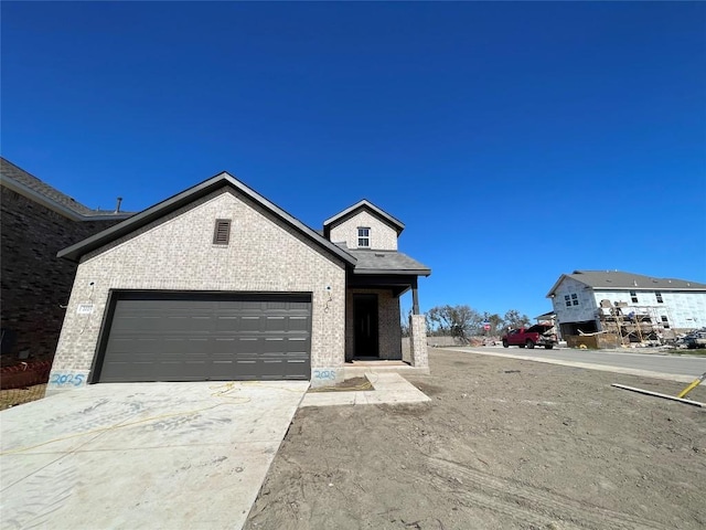 view of front facade featuring a garage, brick siding, and driveway