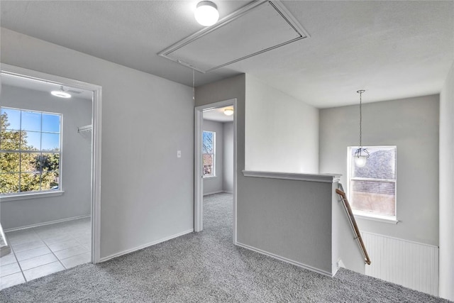 carpeted empty room featuring plenty of natural light and a textured ceiling