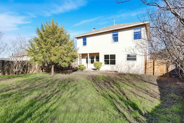 rear view of property featuring a lawn