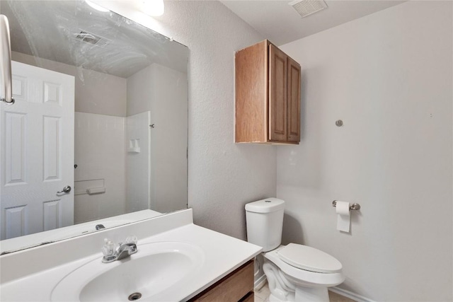 bathroom featuring vanity, toilet, and walk in shower