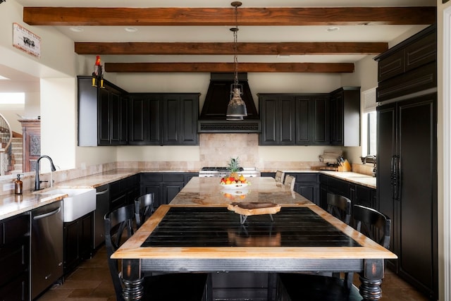 kitchen featuring sink, premium range hood, light stone countertops, decorative light fixtures, and stainless steel dishwasher