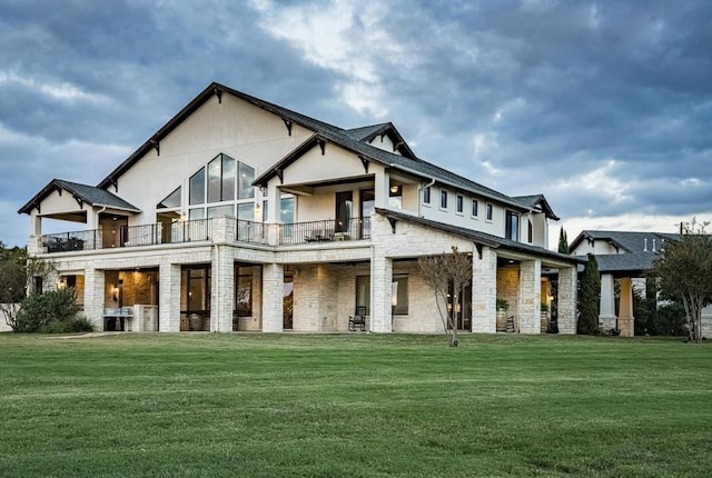 back of house featuring central AC unit, a yard, and a balcony